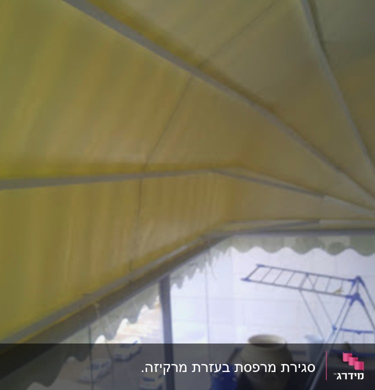 סוכך צהוב מתקפל על מרפסת